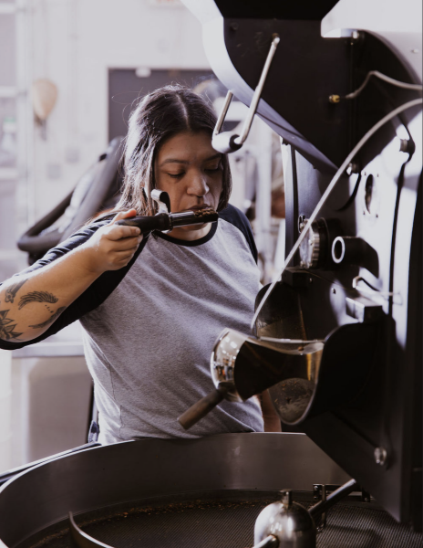TCC alumnus Marisa Zapata tests coffee beans. She is the head roaster 
for Novel Coffee Roasters.
