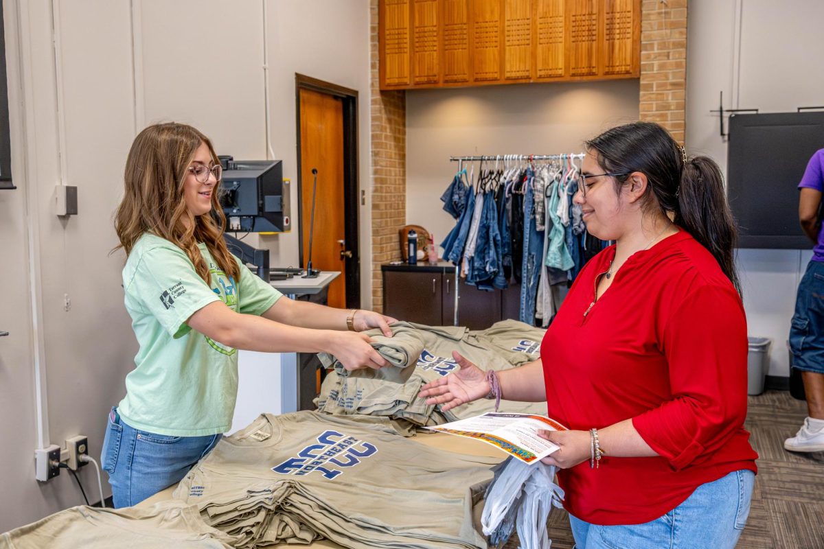 NE student Patricia Marrero accepts a free shirt from student 
worker Mary Keller at the pop-up closet event. 
