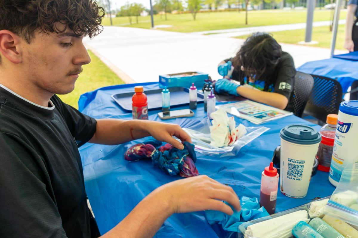Student peer leader Jay Romero and student worker Annalie Herrera design shirts at the NW tie-dye and pool party.