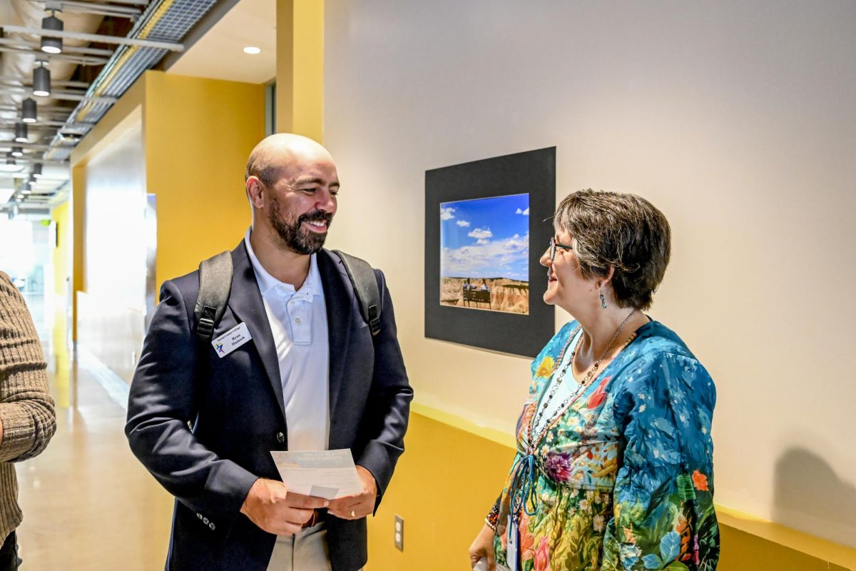 Ryan Hamzeh, NW director of student success and advising, congratulates Liz Bradley on her first photography exhibit on the campus Sept. 22. 