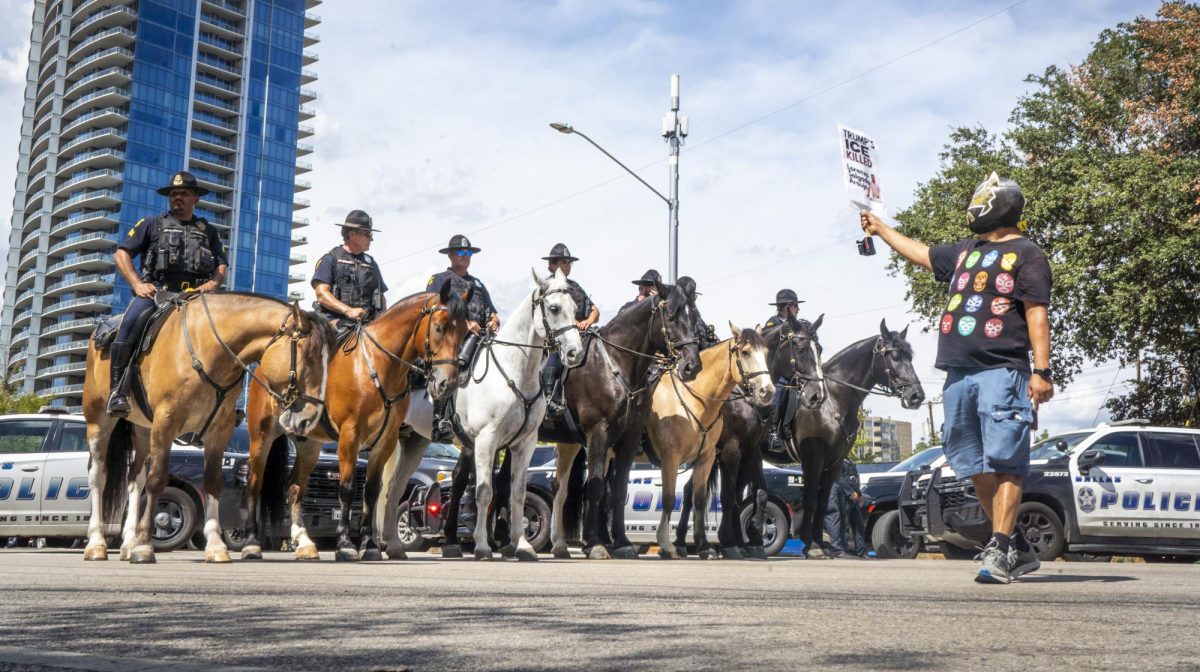 A masked protester confronts the Dallas Police Department Mounted Unit on Harry Hines Boulevard Sept. 10.