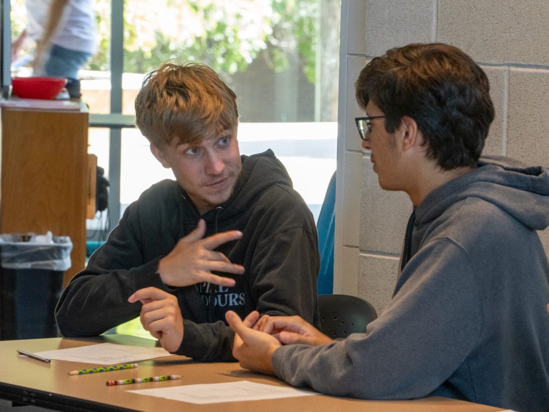 At TR during Deaf Deaf World event, Flower Mound High School students Ghirin Newton and Tristen Howard exchange American Sign Language signs Oct. 8. 