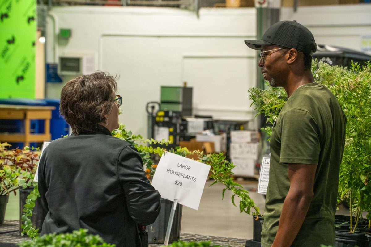NW horticulture lab manager Cameron Grant tells academic adviser Liz Bradley about the options at the plant sale Oct. 2.