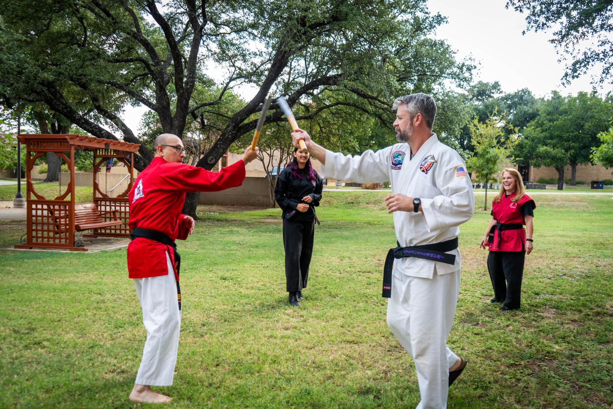 NE math assistant professor Joel Gutierrez and instructor Grant Griffin perform martial arts skills with escrima sticks used to 
teach striking, blocking and footwork Sept. 18 on NE Campus. 