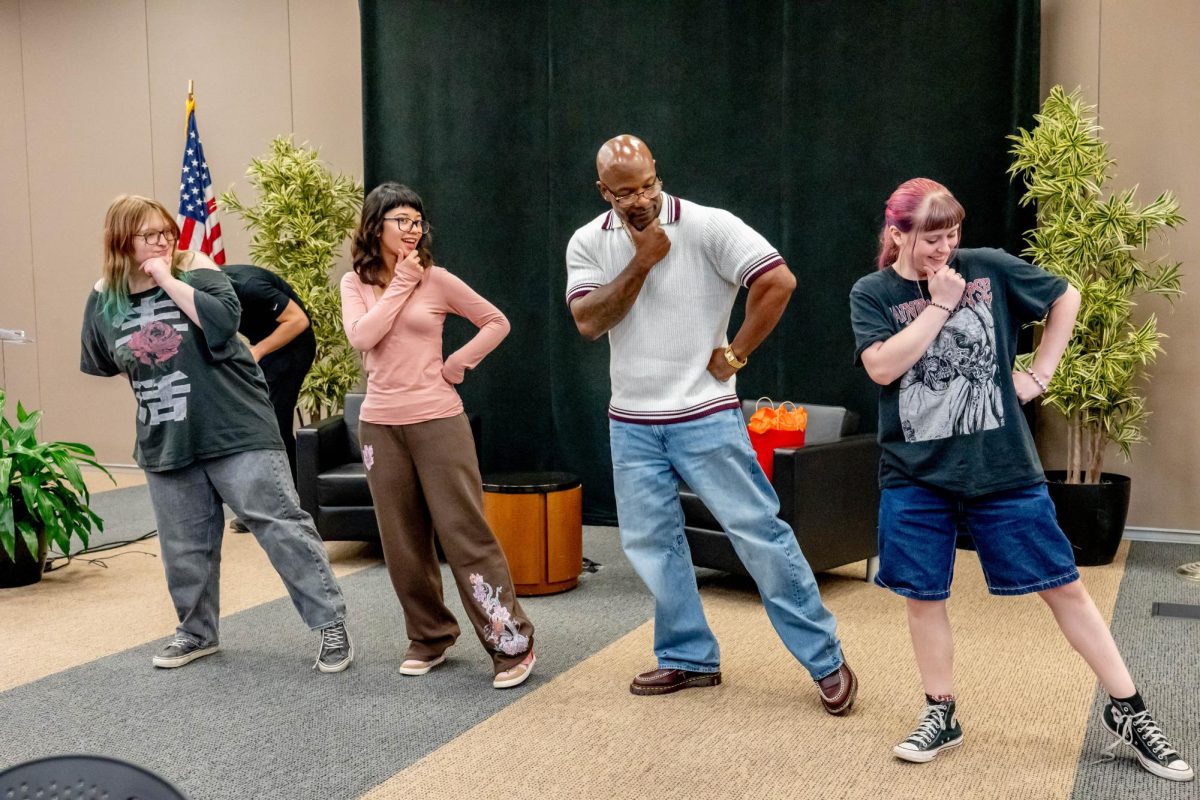 TR students Hayley Blanks, Alexa Gonzalez and Peyton McIlhargey learn a bodybuilding pose Oct. 19 with former Mr. Olympia contestant Antione Williams. 